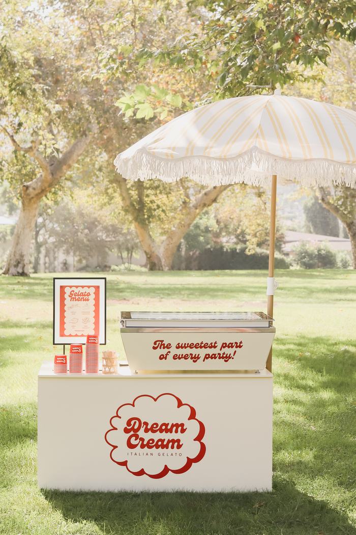 Dream Cream cart set up under an umbrella with menu sign and cups
