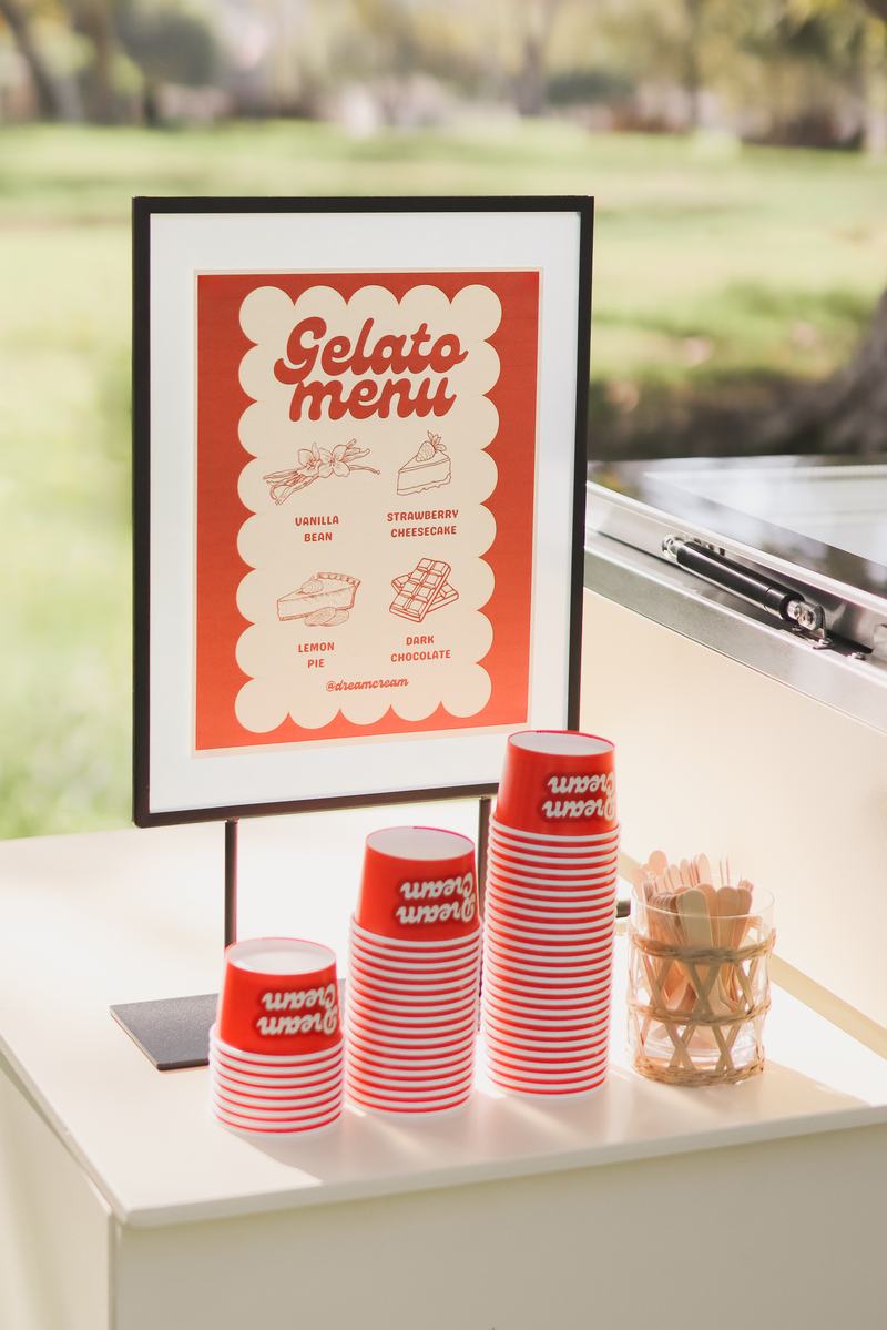 Gelato menu board and cup stacks set up at an event