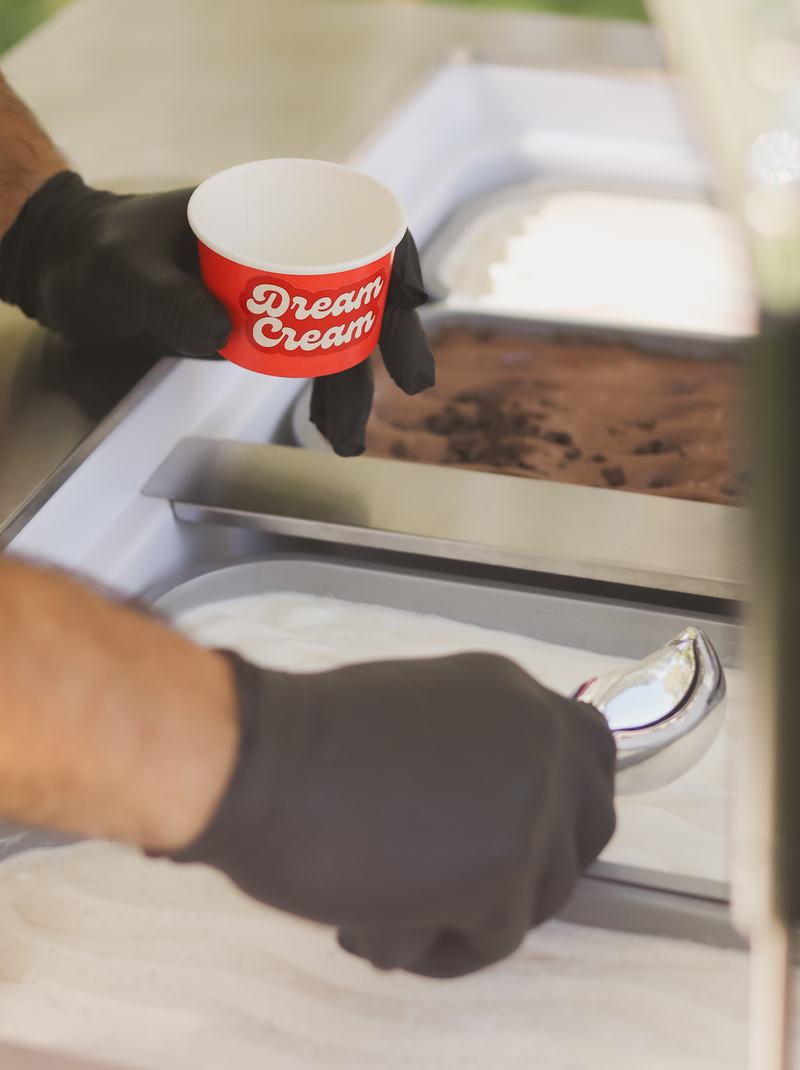 Server scooping gelato from the cart into a Dream Cream cup